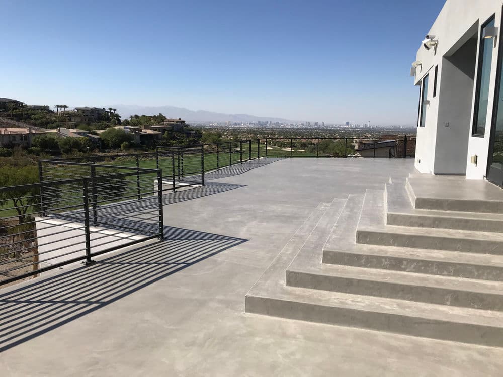 Modern concrete patio with panoramic city view and sleek railing design.